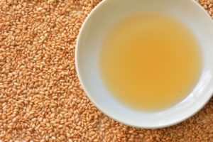 敷き詰められた白ごまと皿に注がれたごま油